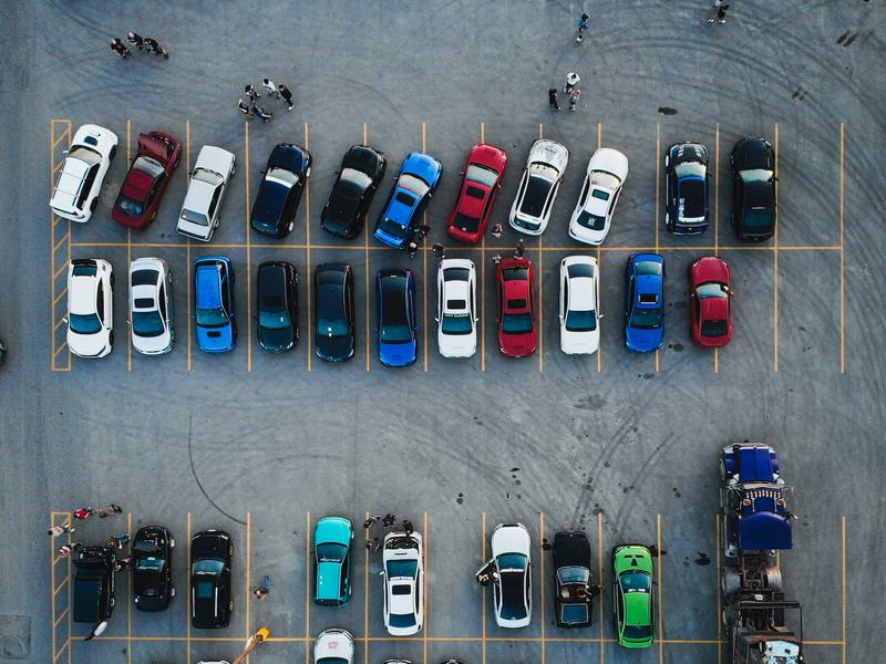 Aerial view of a parking lot filled with cars in many colors